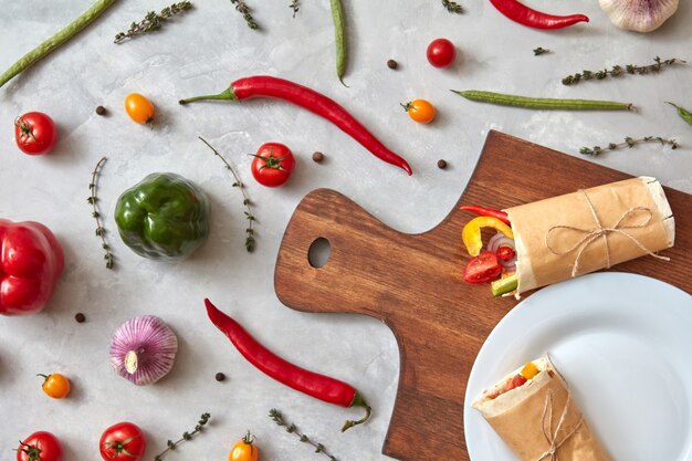 Burrito aux légumes sur une assiette et sur une planche de bois