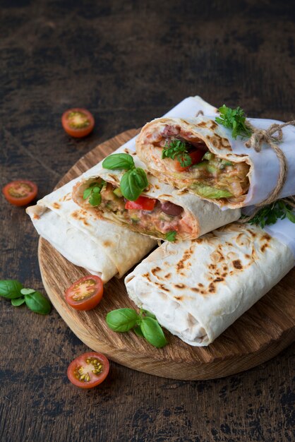 Burrito mexicain traditionnel avec des haricots et des légumes sur un espace rustique