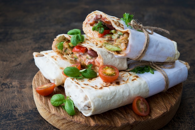 Burrito mexicain traditionnel avec des haricots et des légumes sur un espace rustique