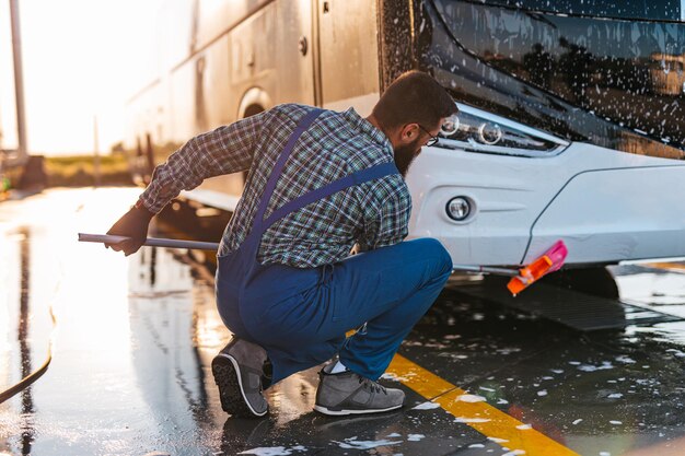 Bus de lavage de jeune travailleur masculin.