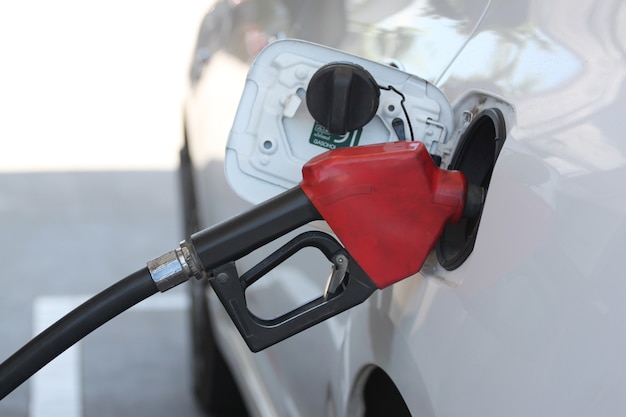 Buse de carburant rouge en versant à la voiture.