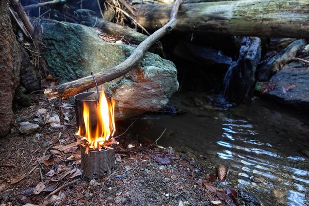 Bushcrafting avec une casserole et de l'eau bouillante sur un feu