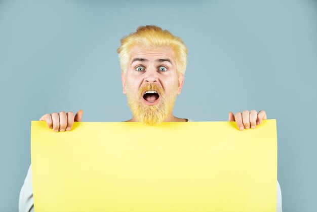 Photo business concept man holding blank paper board studio portrait présentation insérer du texte ou un slogan ma...