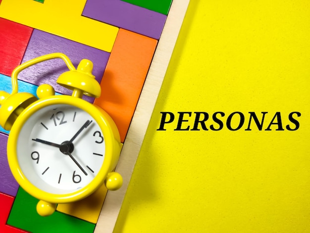 Business ConceptText PERSONAS avec horloge et puzzle en bois sur fond jaune