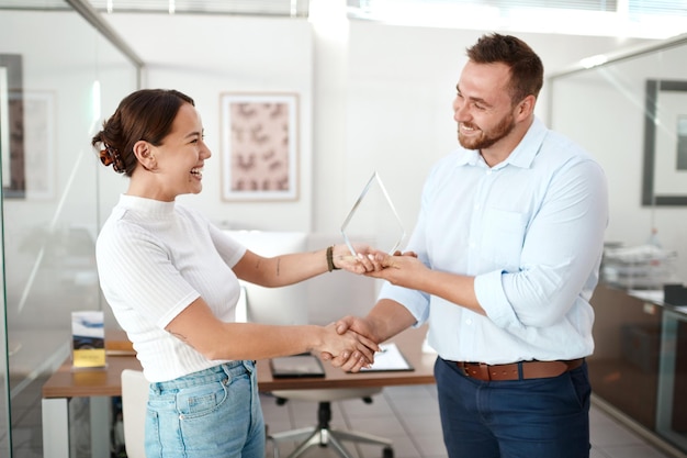 Business people award and handshake for winner employee and best salesman win Congratulations thank you and happy with support success and achievement at company with smile and trophy at work