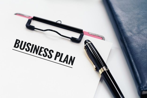 Business plan concept, stylo et presse-papiers avec mot Business plan, lunettes et livre de journal intime