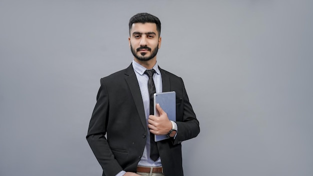 Businessman hand in pocket holding tab à gauche en costume noir indien pakistanais