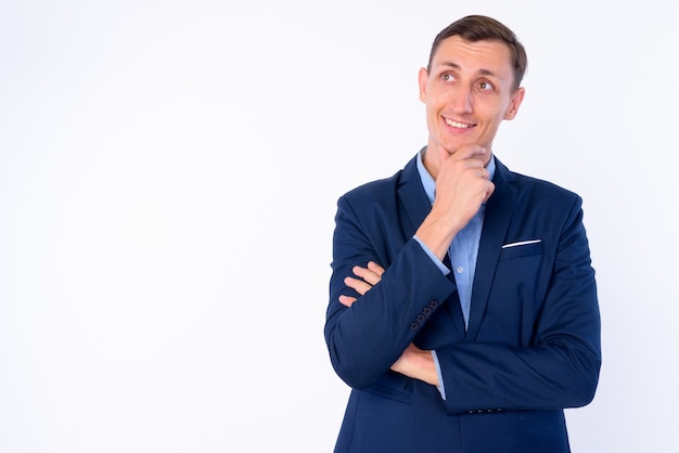 Businessman wearing suit isolé contre le mur blanc