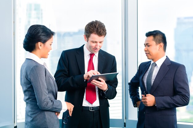 Businesspeople standing at office windo travaillant