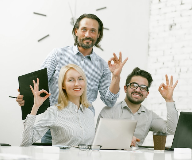 Businessteam souriant montrant des gestes ok au bureau
