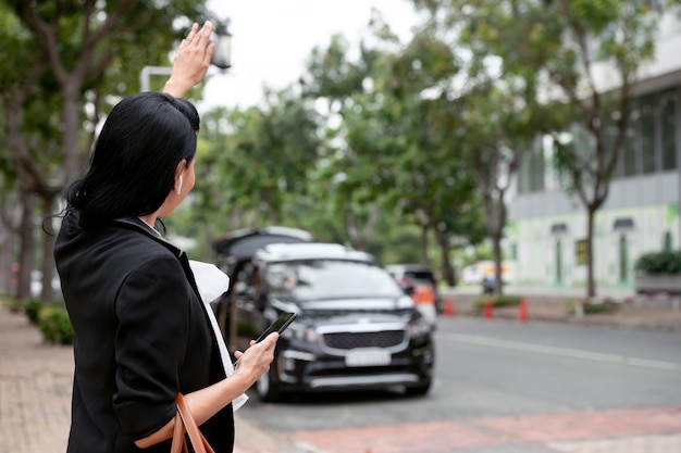 Photo businesswoman attendant son taxi à l'extérieur