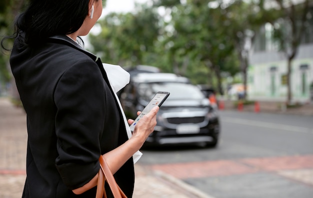 Businesswoman attendant son taxi à l'extérieur