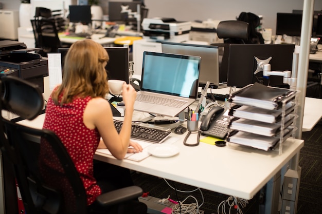 Businesswoman buvant du café au bureau