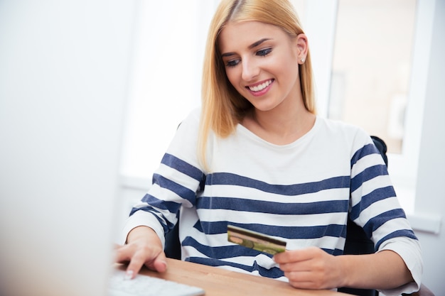 Businesswoman holding carte bancaire et en tapant sur le clavier