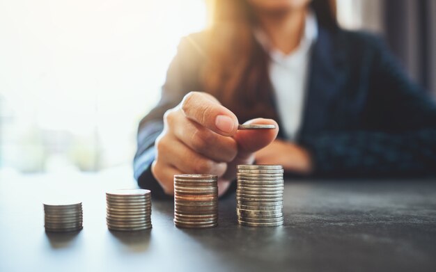 Businesswoman holding et empiler des pièces sur la table