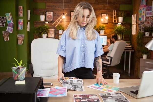 Businesswoman in creative office en regardant des dessins. Créatrice de femme.