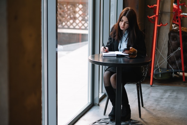 Businesswoman parler au téléphone et prendre des notes