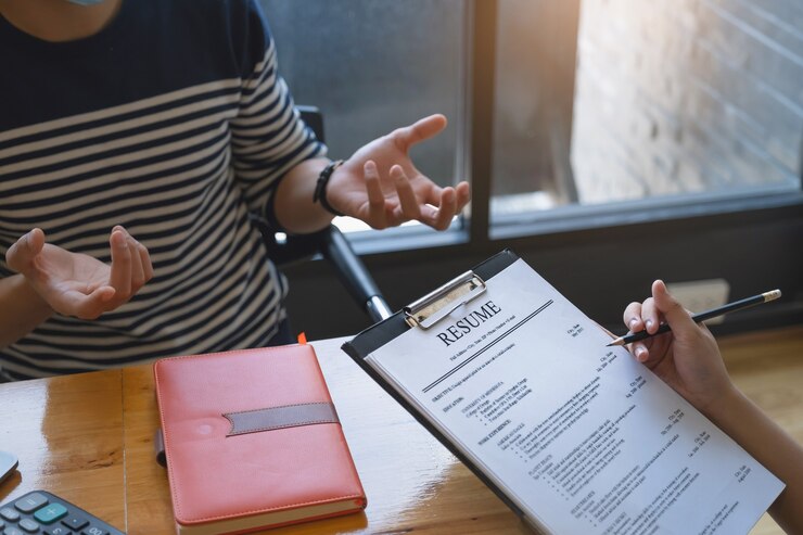 Photo businesswoman reading cv de l'homme sur le document lors d'une entrevue.