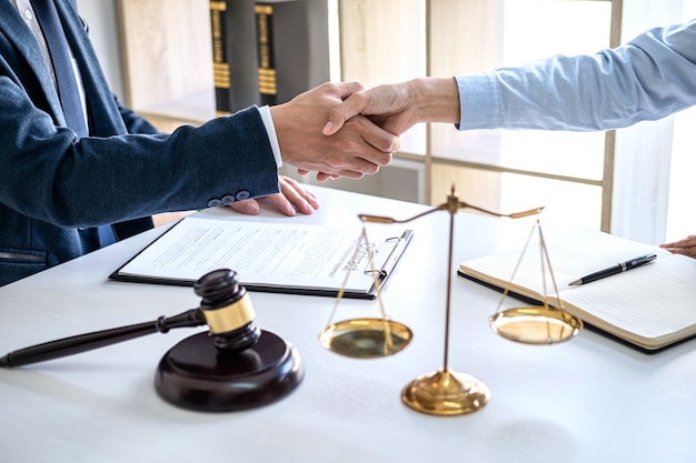 Businesswoman serrant la main d'un avocat après avoir discuté de beaucoup de contrat dans la salle d'audience