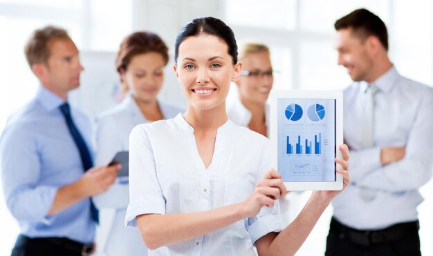 Businesswoman showing tablet pc avec des graphiques in office