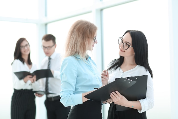 Businesswoman signer un document commercial, debout dans le bureau