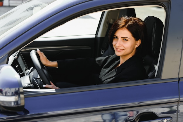 Photo businesswoman sitting in siège du conducteur dans sa voiture