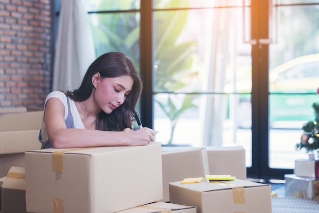 Businesswoman taping une boîte en carton