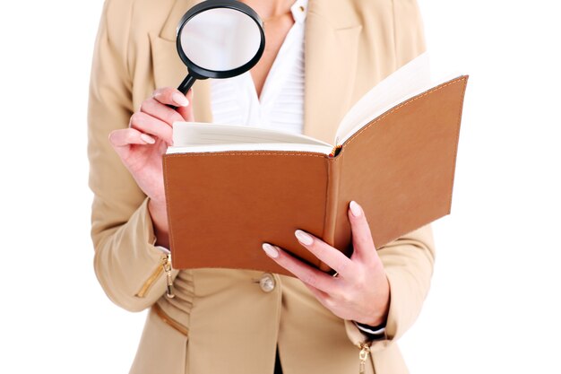 Businesswoman with agenda et loupe sur fond blanc