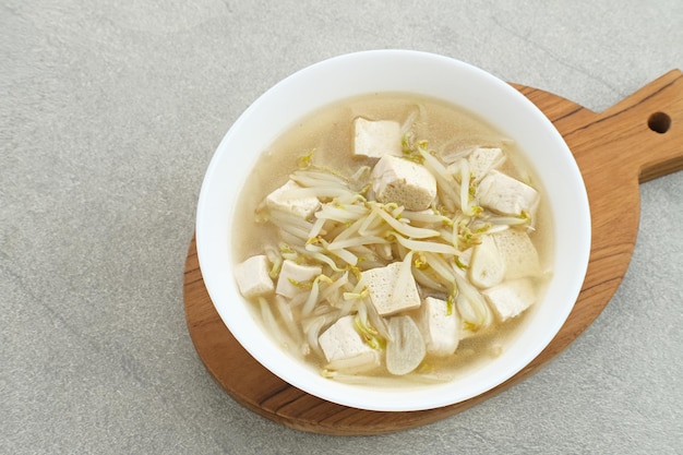 Ca Tauge ou Tumis Tauge indonésien sauté de germes de soja mélangés avec du tofu servi dans un bol blanc