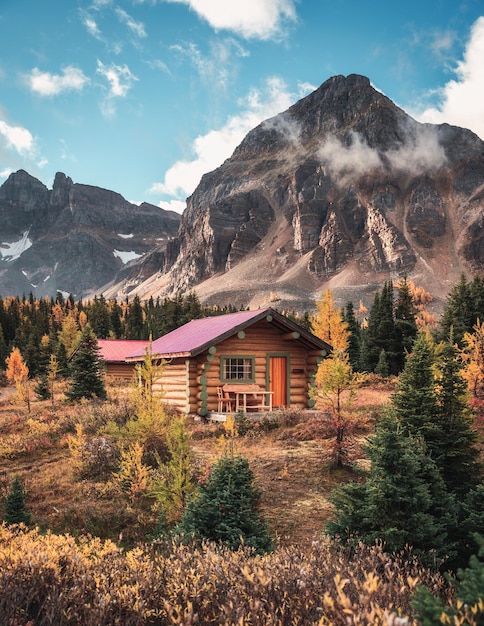 Cabane en bois avec des montagnes rocheuses dans la forêt d'automne sur le parc national