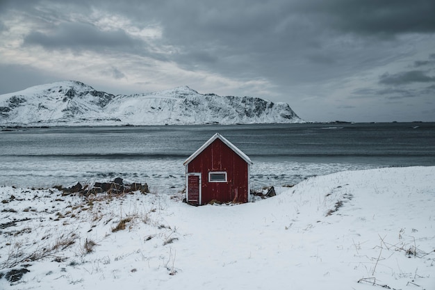 Cabane rouge sur un rivage enneigé