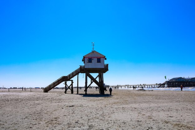 Photo une cabane de sauveteur sur la plage contre le ciel bleu