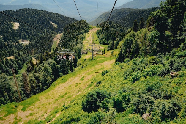 Photo des cabanes modernes avec des gens contre le ciel bleu et les sommets des montagnes rosa khutor soschi russie