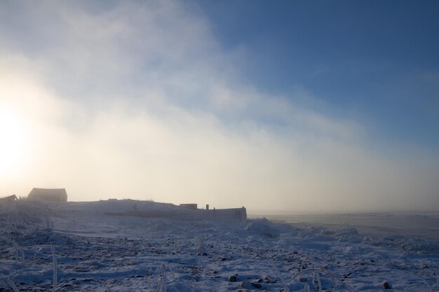 Cabine couverte de neige avec coucher de soleil en arrière-plan près de Churchill au Manitoba