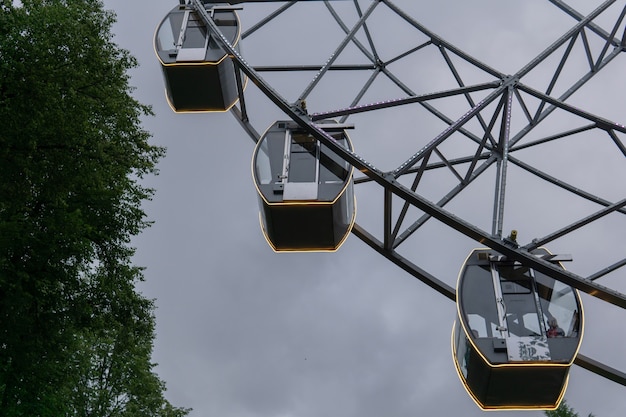 Cabines rougeoyantes d'une grande roue contre le ciel du soir