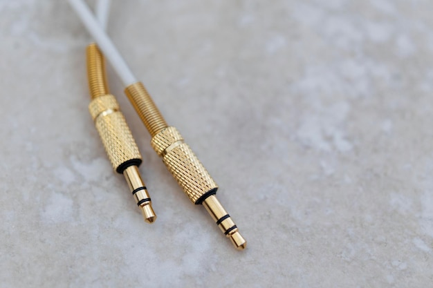 Câble audio blanc avec métal doré sur fond de marbre