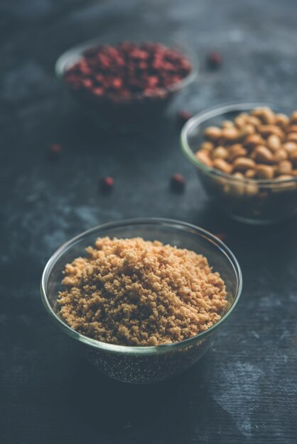 Cacahuètes concassées ou poudre de mungfali avec de l'arachide entière et grillée. Servi dans un bol sur fond de mauvaise humeur. Mise au point sélective