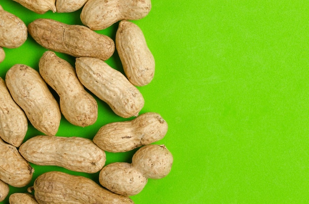 Cacahuètes sur fond vert vif concept pour une alimentation saine