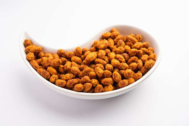 Cacahuètes masala croustillantes et épicées enrobées de besan indien ou mungfali servies dans un bol ou une assiette