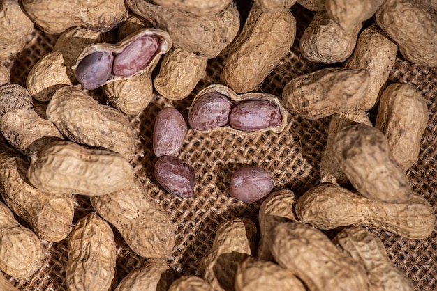 Les cacahuètes pelées sont placées parmi de nombreuses cacahuètes