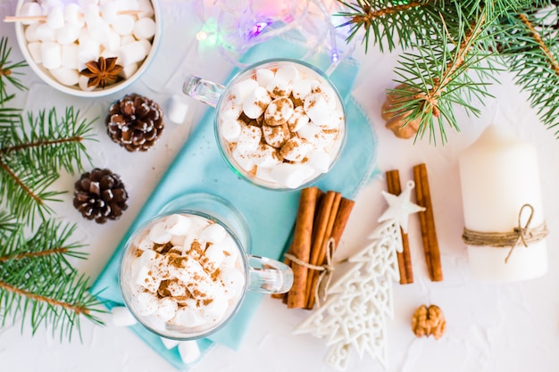 Cacao chaud à la guimauve et cannelle moulue dans des verres dans des décorations de Noël, vue de dessus