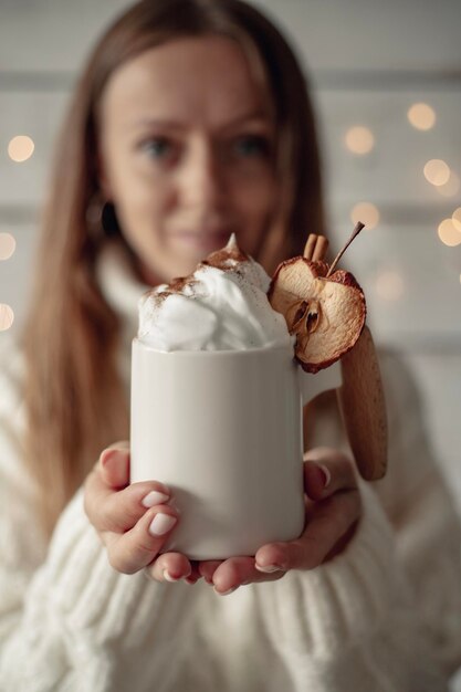 Le cacao est décoré de crème fouettée, de cannelle et de pomme séchée.