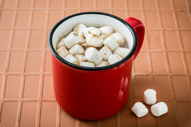 Cacao de Noël à la guimauve dans une tasse sur le marron