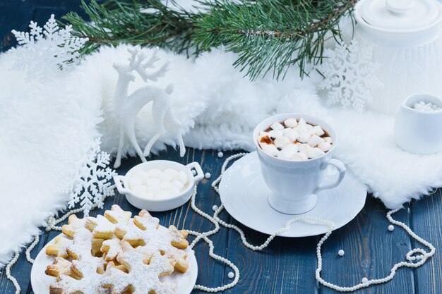 Cacao de Noël avec des guimauves et des cookies sur fond de bois