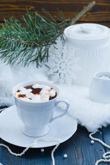 Cacao de Noël avec des guimauves sur table bleue