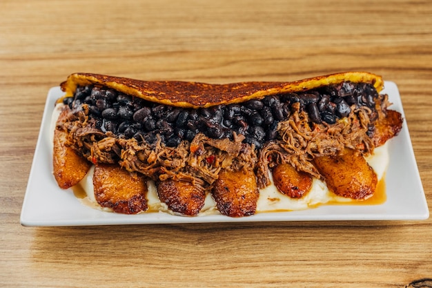 Photo cachapa de pabellon gastronomie vénézuélienne pâte de maïs farcie de haricots noirs plats frits viande et fromage