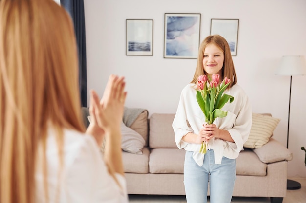 Cadeau au parent La jeune mère avec sa fille est à la maison pendant la journée