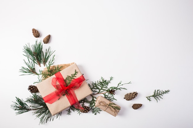 Cadeau, décoration de Noël, branches de cyprès, pommes de pin sur blanc