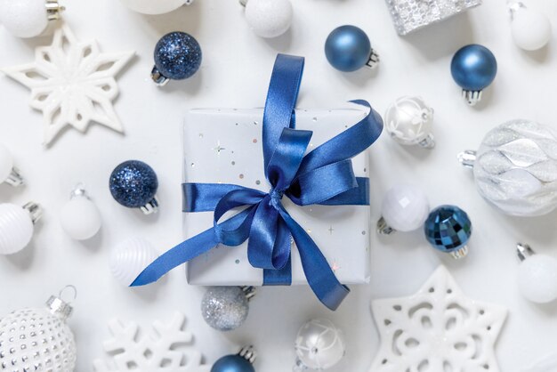 Cadeau de Noël avec arc bleu et décorations argentées vue de dessus