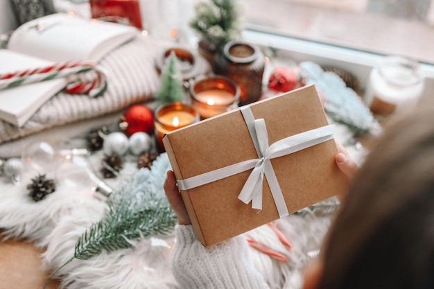 Cadeau de Noël artisanal dans les mains sur le fond du décor de vacances